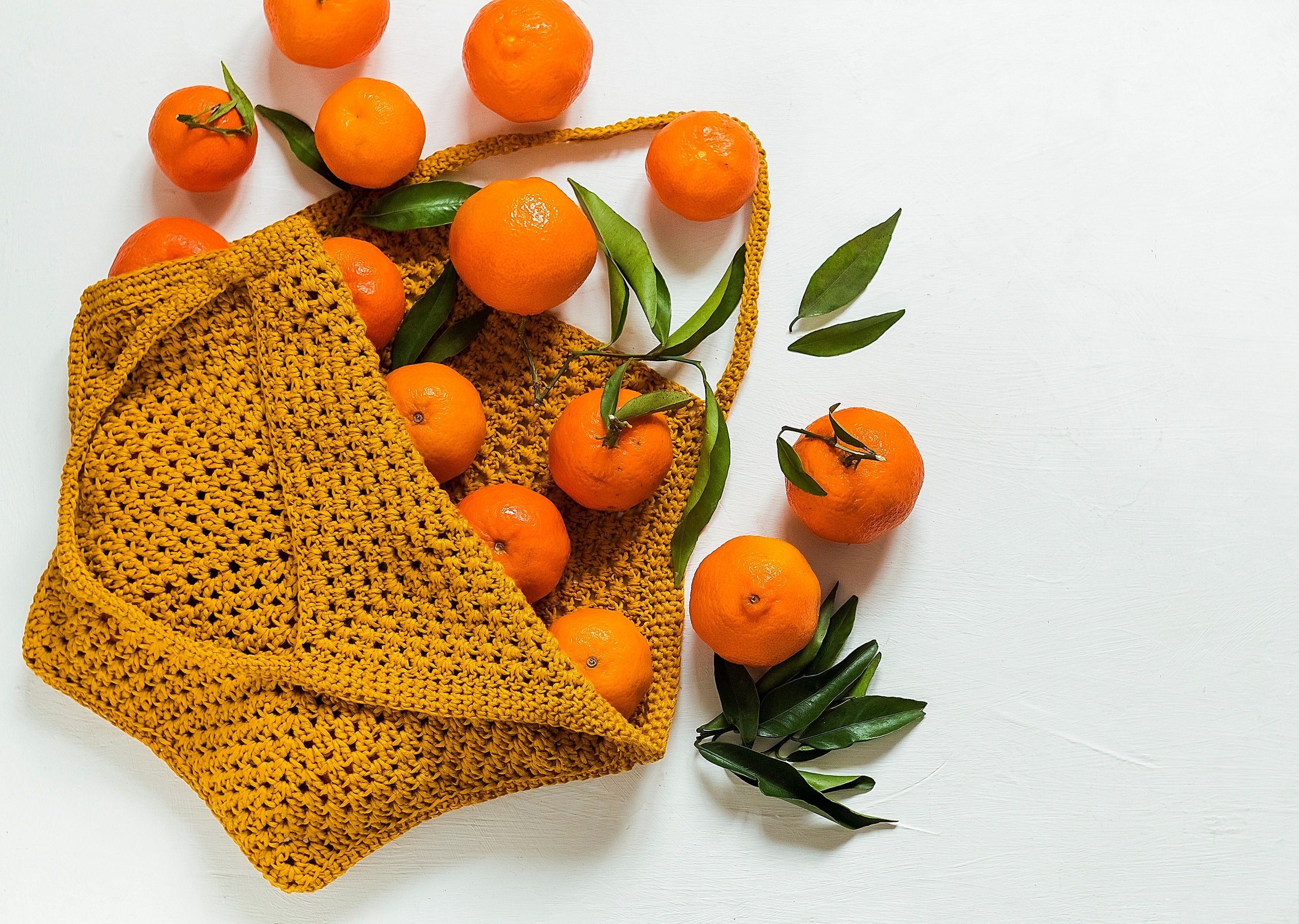 Yellow crochet shopping bag with tangerines