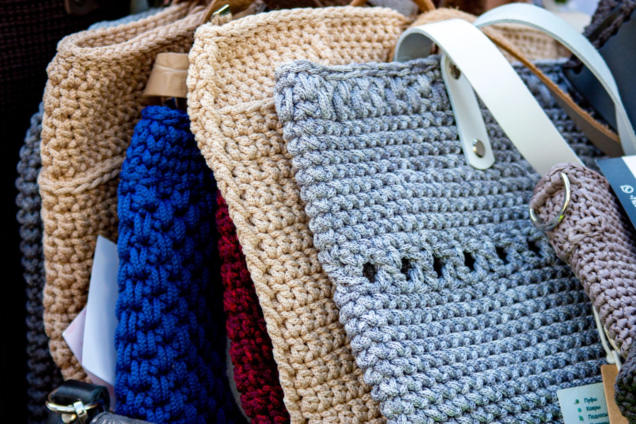 Storefront display featuring handmade knitted and crochet bags
